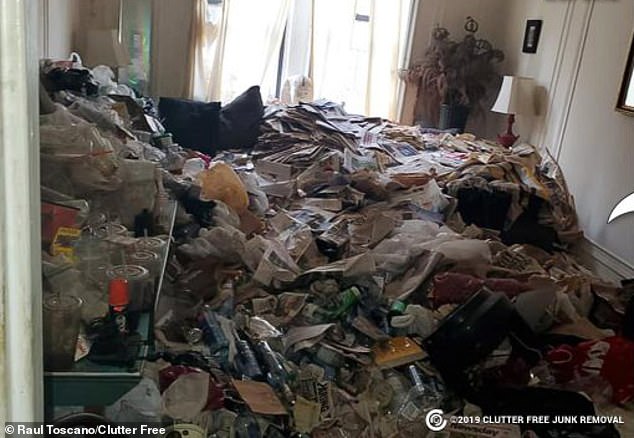 A cleaning crew focused on hoarding took a photo of empty food containers, bottles, newspapers and trash piled waist-high in the living room of an elegant antebellum apartment building in New York City