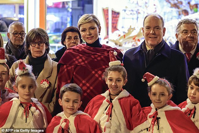 The royals are pictured at the festive event with children dressed in Christmas outfits at the event