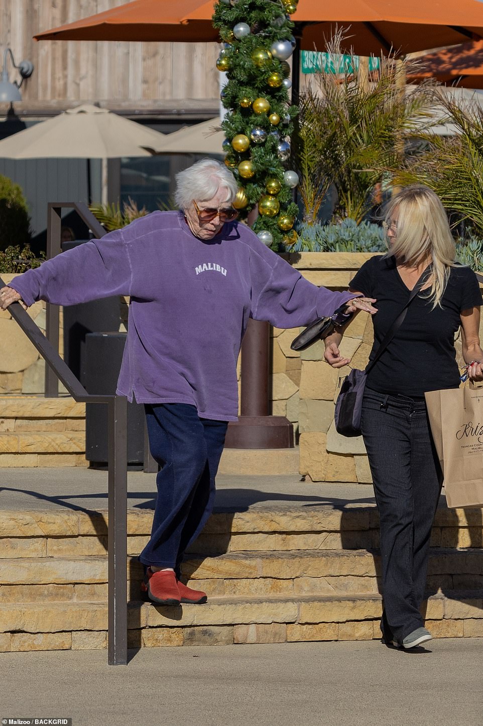 Casual: For the laid-back outing, the mother-of-one wore a pair of oversized brown shades, which shielded her blue eyes from the sun, a purple 'Malibu' sweatshirt, dark-wash jeans and red loafers