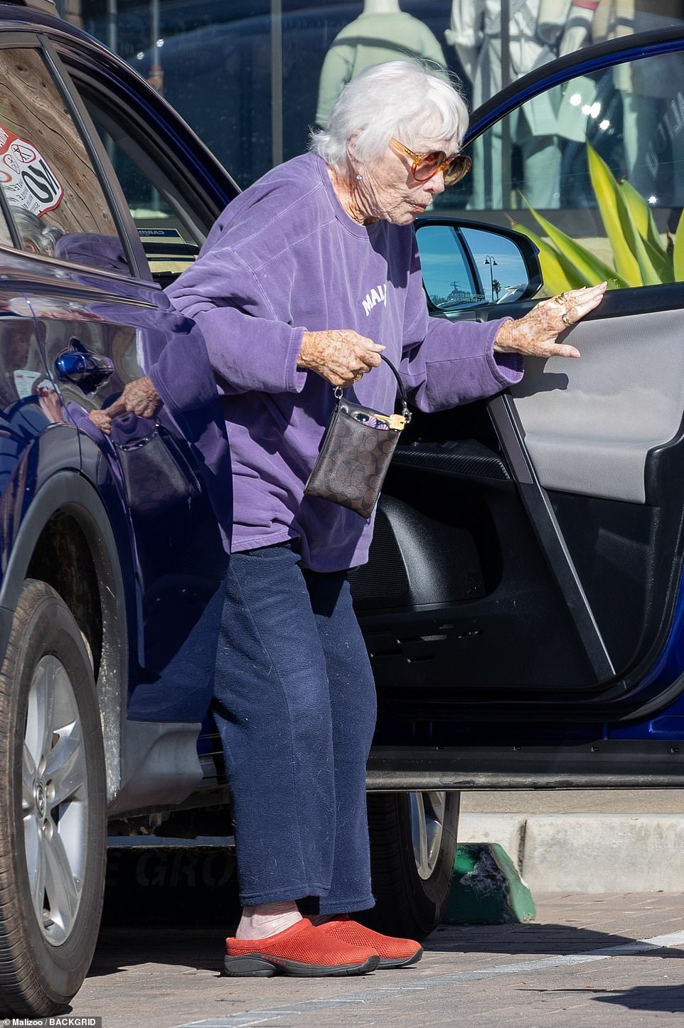 Driving around: MacLaine was seen getting out of the passenger seat while holding a small Coach bag