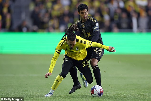 Columbus Crew's Mohamed Farsi (in yellow) and LAFC's Carlos Vela battle for the ball