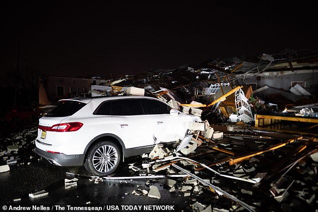 A car is buried under rubble on Main Street after a tornado struck Hendersonville