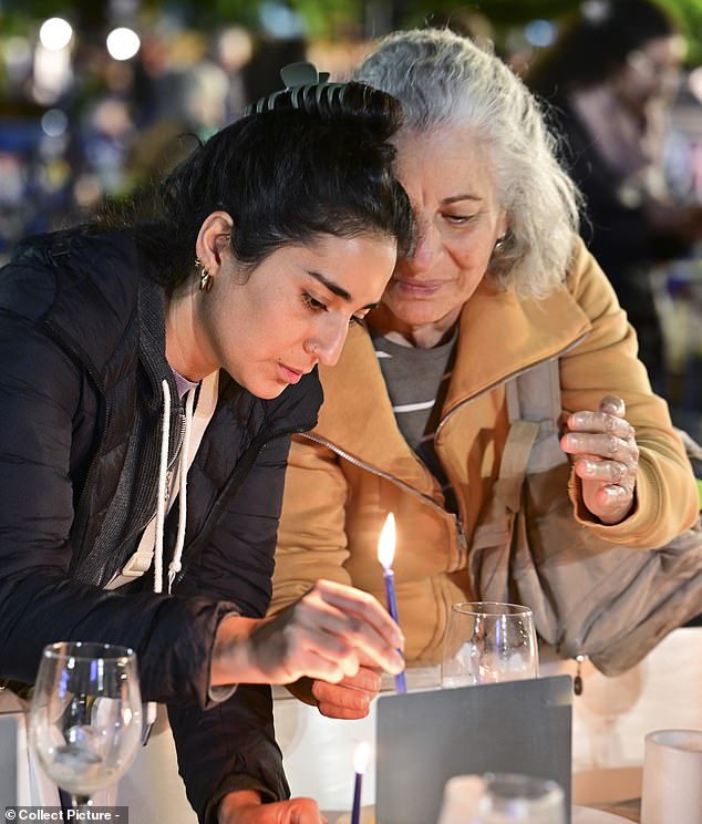 Israelis gather to light candles during a vigil marking the second night of Hanukkah on December 9