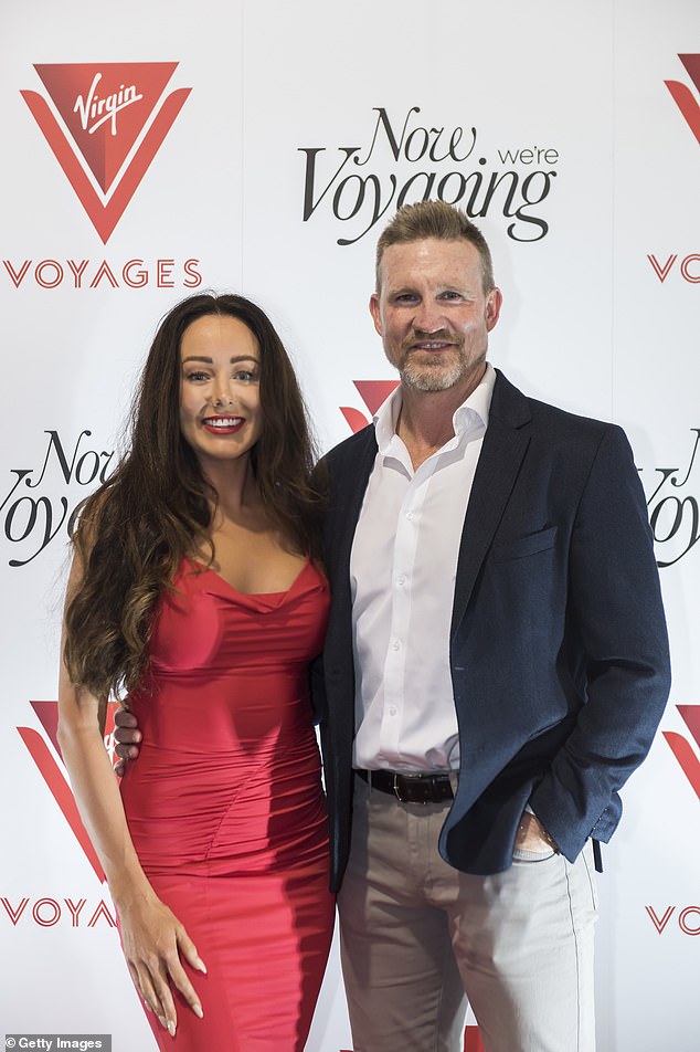 The AFL legend and his glamorous partner posed side by side as they cuddled on the red carpet.  Brodie stunned in a red maxi dress that clung to her incredible figure