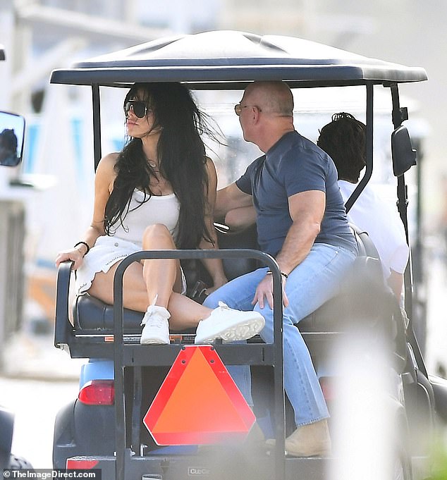 The elegant Sánchez crossed her legs after jumping onto the back of the golf cart as her husband-to-be took her hand and held it adoringly during the short journey