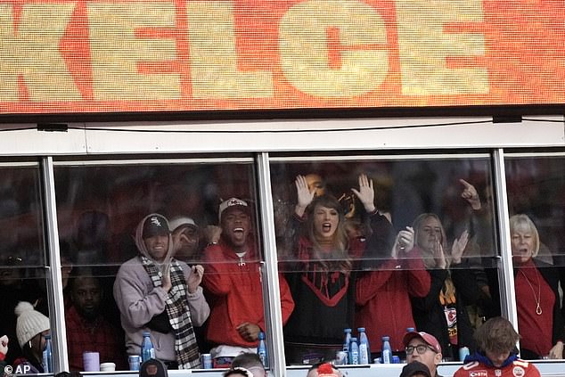 Taylor bangs on the glass of Travis' suite at Arrowhead while watching the game in KC
