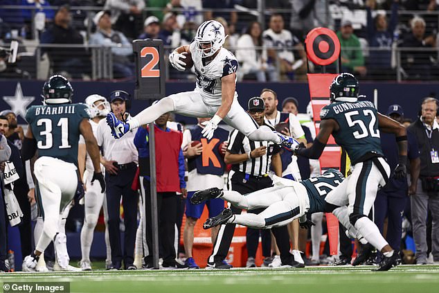 Ferguson (above) jumps over Kelee Ringo of the Eagles during the fourth quarter at AT&T