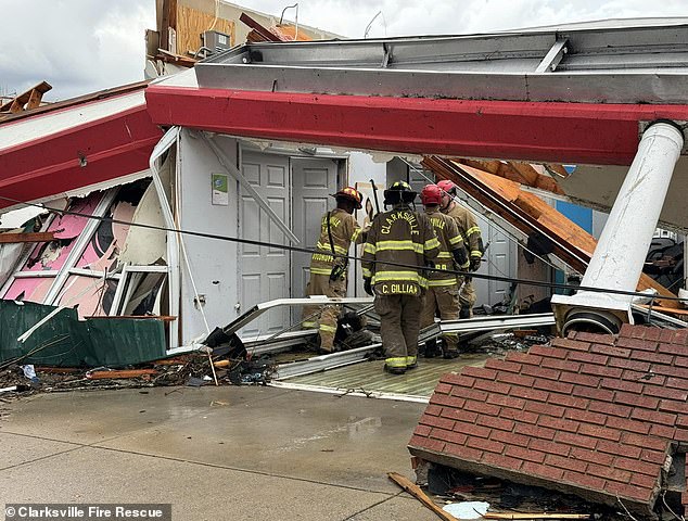 Firefighters in Clarksville try to enter a damaged home.  At least three people were killed in the city