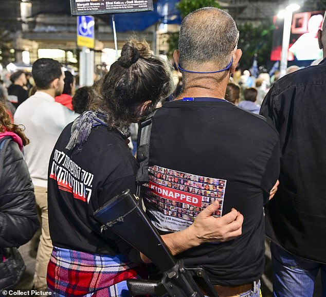 A couple embraces during the emotional vigil held in Hostage Square, Tel Aviv