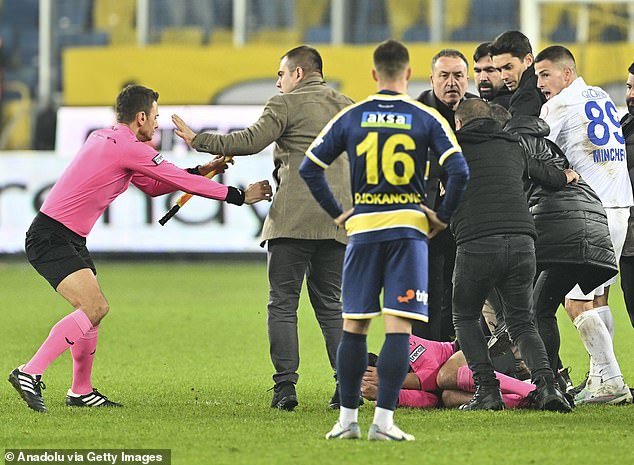 A linesman rushes in to assist referee Halil Umut Meler after being knocked to the ground by Ankaragucu President Faruk Koca