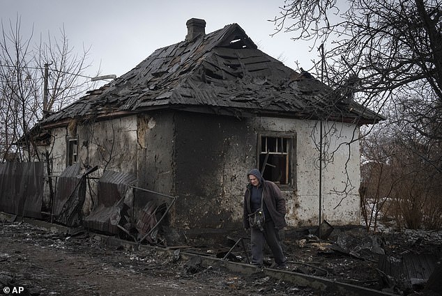 A local resident passes a private house damaged by the Russian missile attack in Kiev, Ukraine on Monday