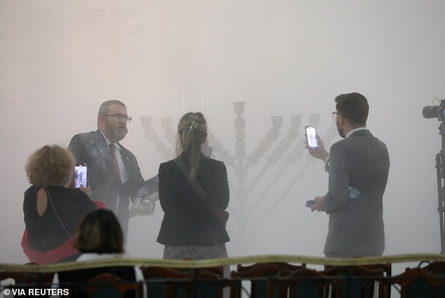 Grzegorz Braun, far-right Polish MP from the Konfederacja party, stands after using a fire extinguisher to extinguish Hanukkah candles in parliament in Warsaw