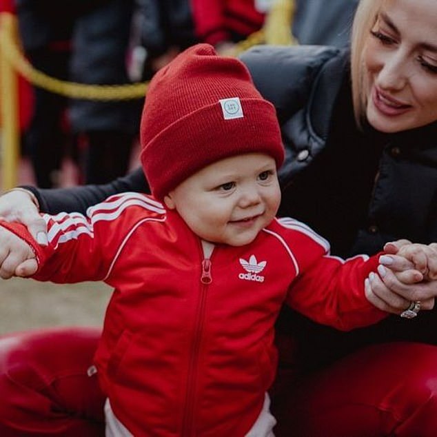 She also helped him up as he strolled around in a Chiefs red tracksuit and matching hat