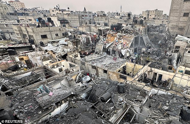 People search through the rubble of damaged buildings after an Israeli airstrike on Palestinian homes, amid the ongoing conflict between Israel and Hamas