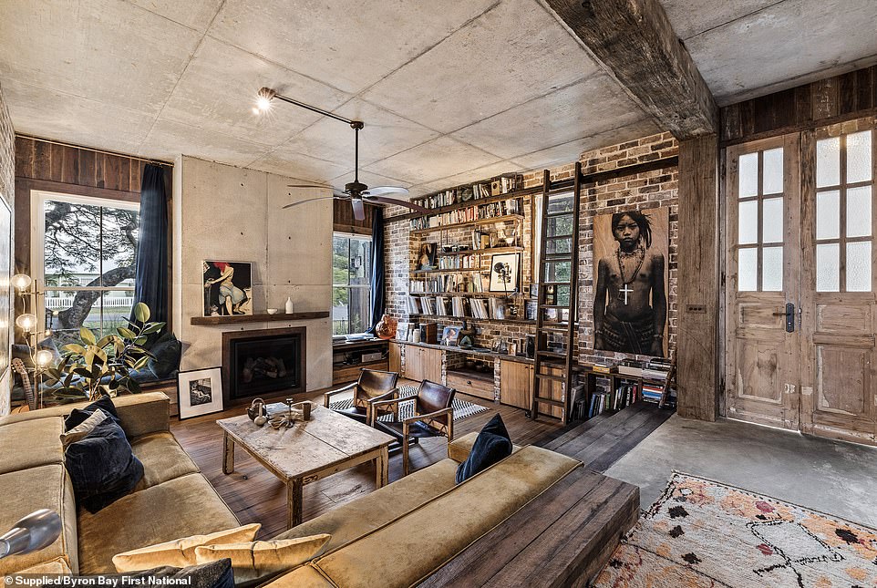 Guests pass a pebble-strewn fish pond to enter the home, where they are greeted by a foyer and an intimate sunken lounge or conversation pit with a warming fireplace and a rolling library ladder shelf