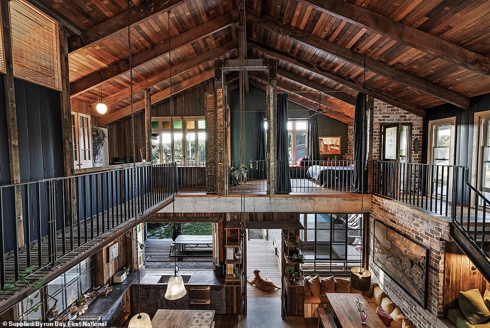 At the end of the hall is the farmhouse kitchen with high ceilings, vintage decor and furnishings, as well as a black steel fireplace and built-in cabin-style dining room.