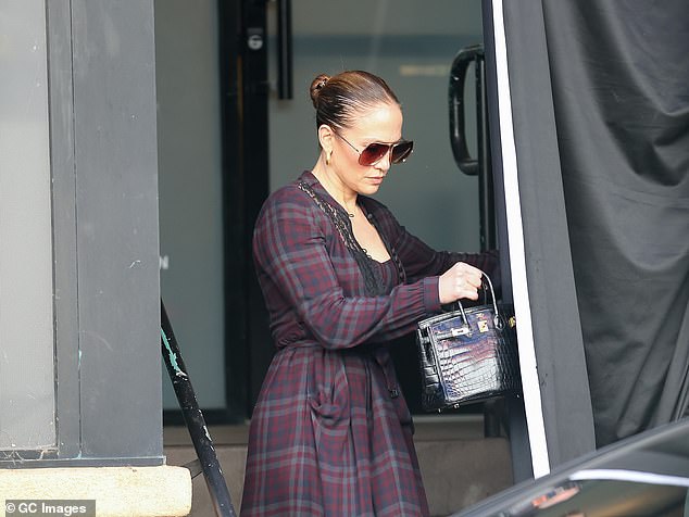 The entertainer wore her hair pulled back into a tight bun while wearing a plaid jacket and sunglasses as she left a workout studio