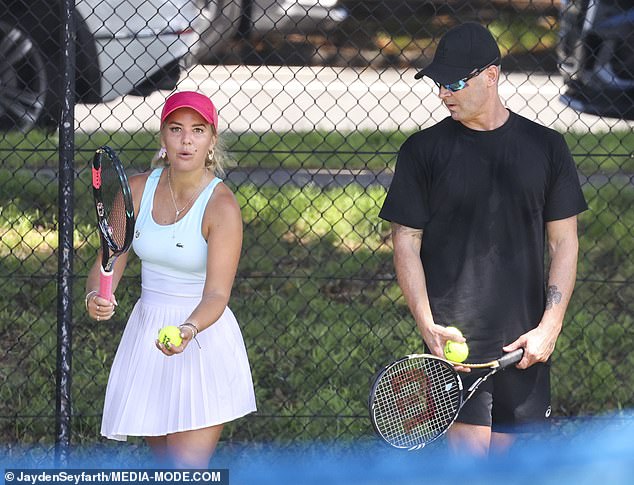 Michael dressed casually in black shorts, a matching colored T-shirt and a cap as he picked up his racket