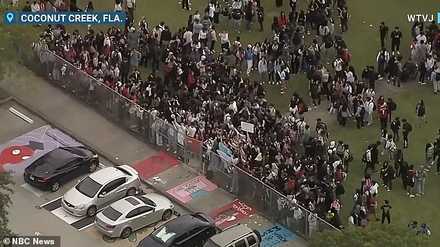 They gathered on the football field waving signs in support of their peers and chanting 'trans lives matter'