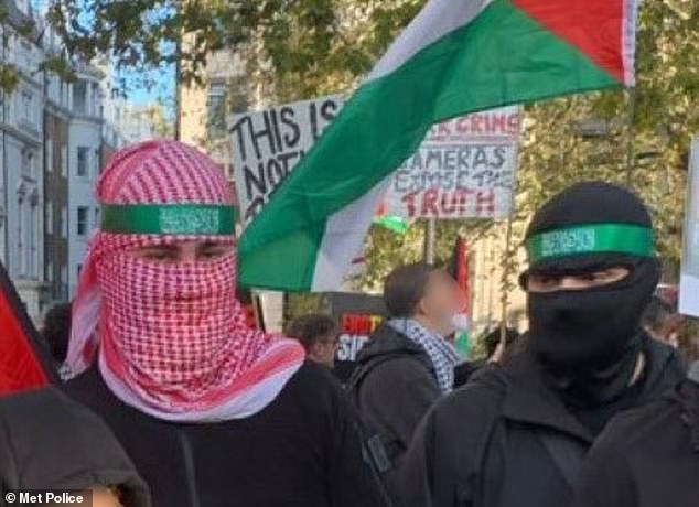 Two men pictured wearing alleged Hamas-style headbands, their balaclavas and scarf-covered faces during a protest in London on November 11