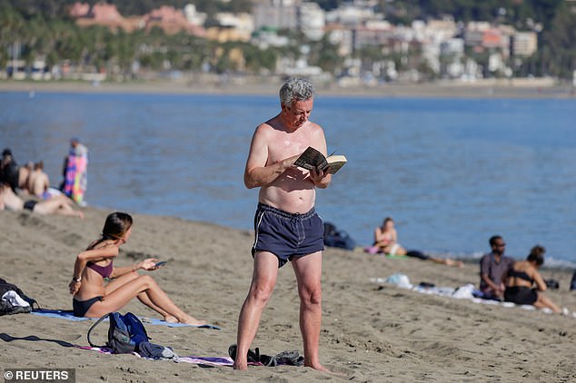 A British tourist was seen reading a book on the unusually warm beach of Malagueta, Malaga