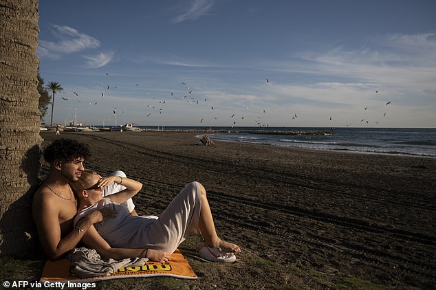 A couple enjoys El Palo beach in Malaga during the heat wave