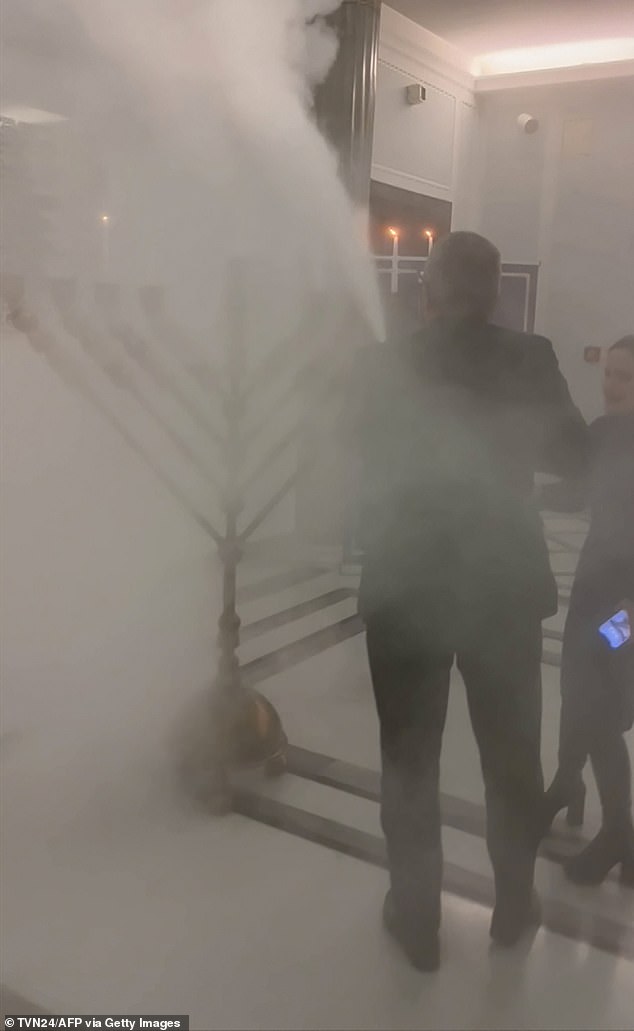 Shocking footage shows Braun extinguishing candles on a menorah lit for Hanukkah as a persistent haze filled the air