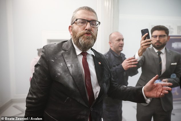 Grzegorz Braun, a member of the far-right Confederation Party, is seen after using a fire extinguisher to extinguish candles on a menorah