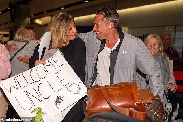 The Hollyoaks star, 48, arrived at his family's home and held 'welcome home Uncle Nick' banners at the gate