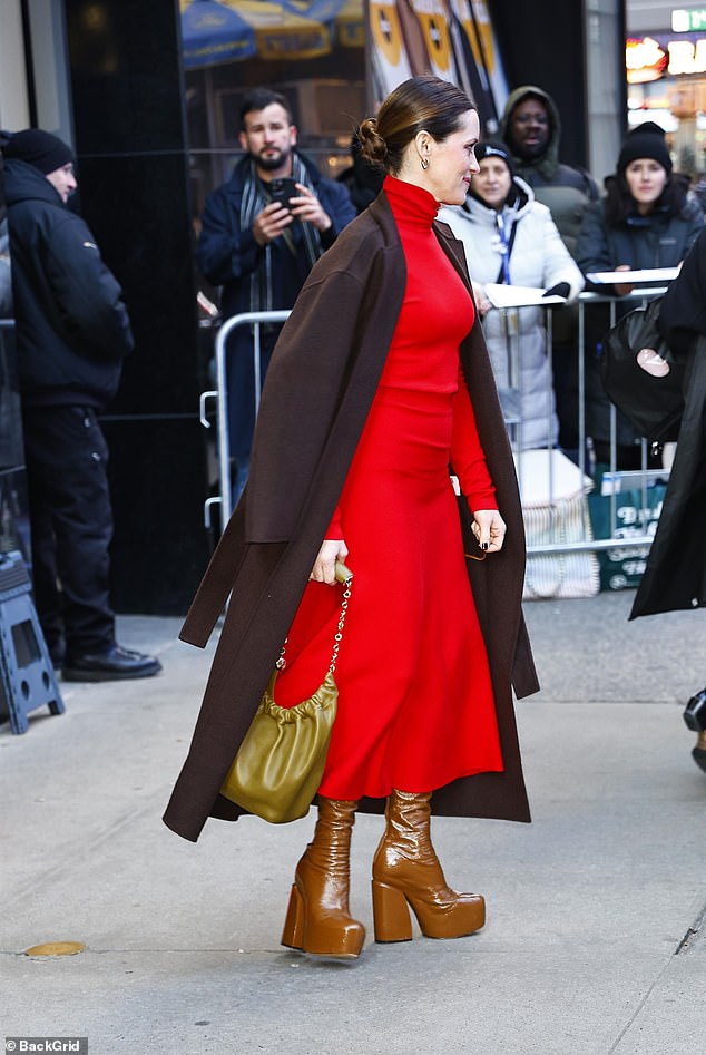 The star completed her stylish look with a matching brown overcoat and patent platform boots