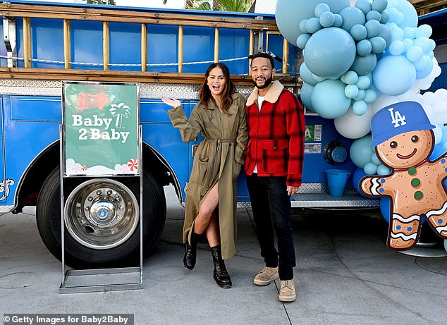 The couple posed together in front of a Baby2Baby truck decked out in blue balloons and a gingerbread man wearing a Dodgers hat