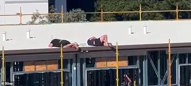 The men (pictured) ignored police calls to come down from the top of the building and decided to take a nap