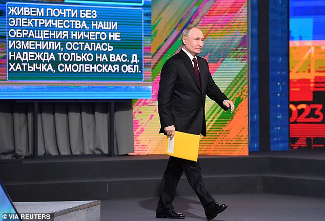 Even as Putin walked into the hall to enthusiastic applause, a message appeared behind him saying: 