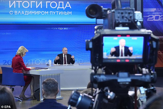 Russian President Vladimir Putin (center) answers questions during his annual press conference with Russian federal, regional and foreign media in the Gostiny Dvor forum hall