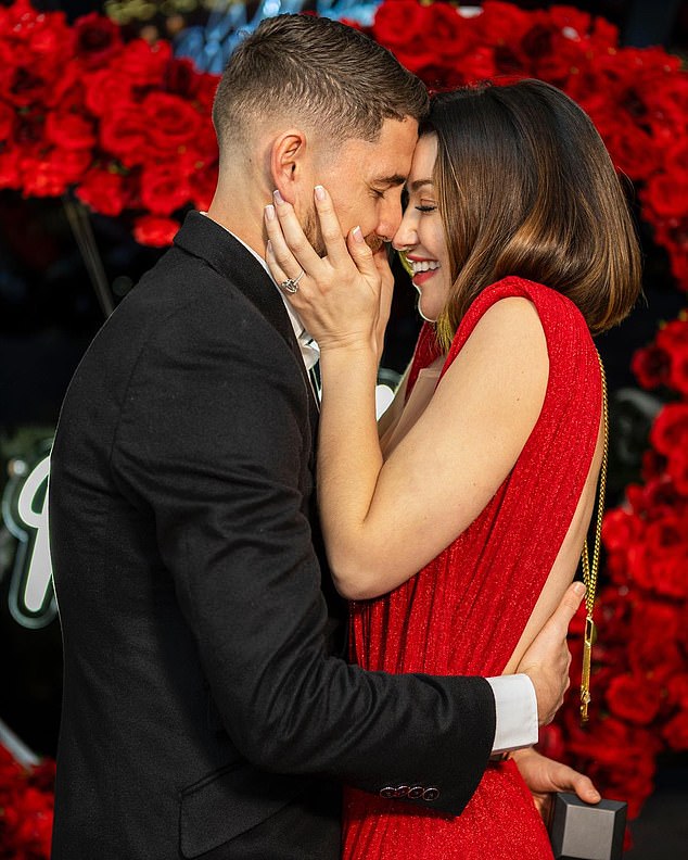 The footballer, 31, got down on one knee in front of the singer, 32, surrounded by red roses and candles as he was serenaded by a violinist