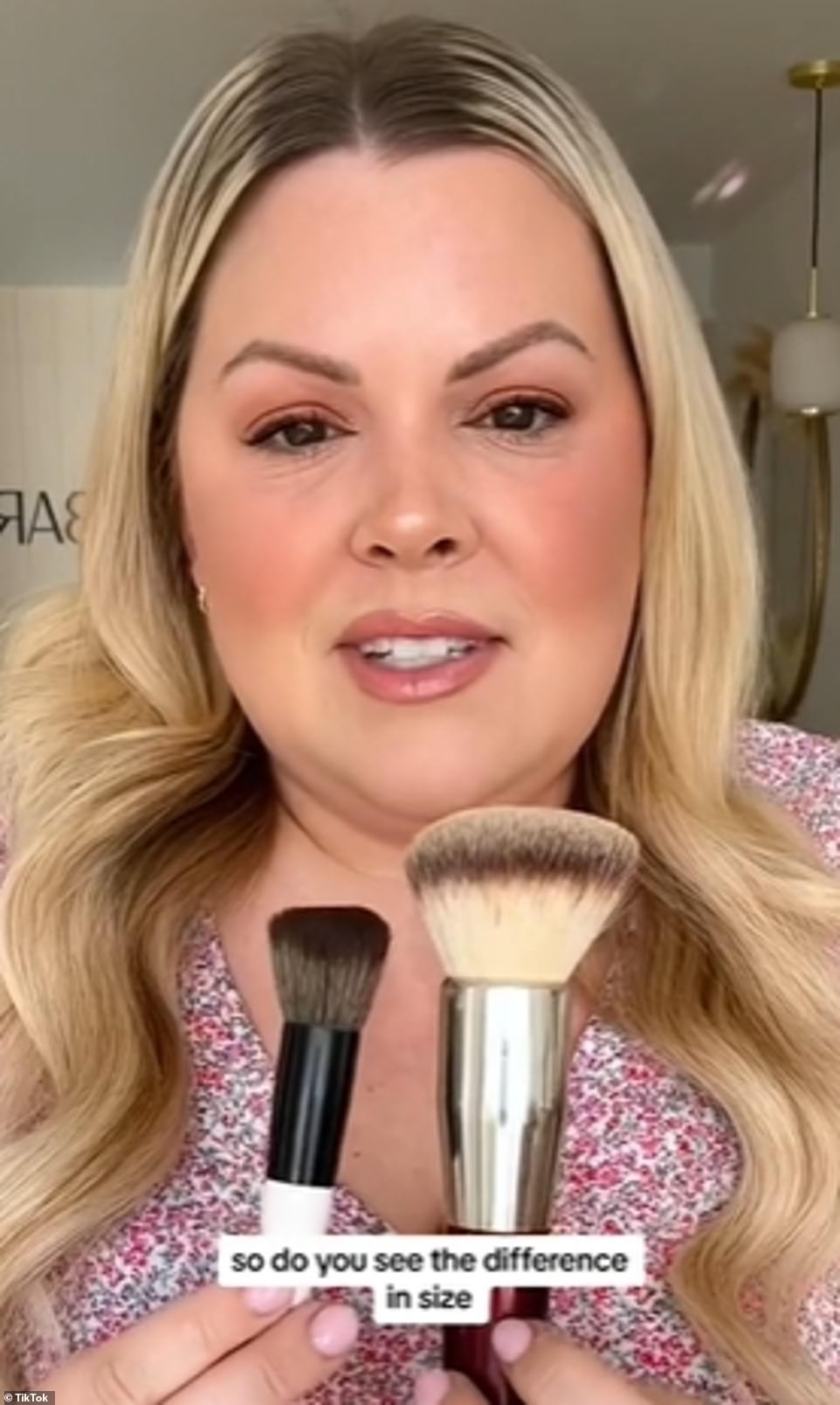 The makeup artist held up the two brushes to compare sizes and explained that the larger one was not as effective, especially when applying blush and bronzer