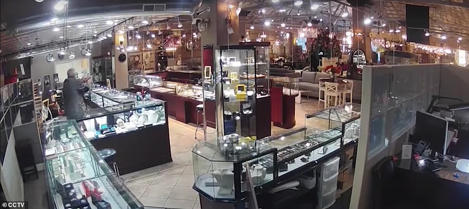 The older employee looked at the robbers with a gun from behind the jewelry counter