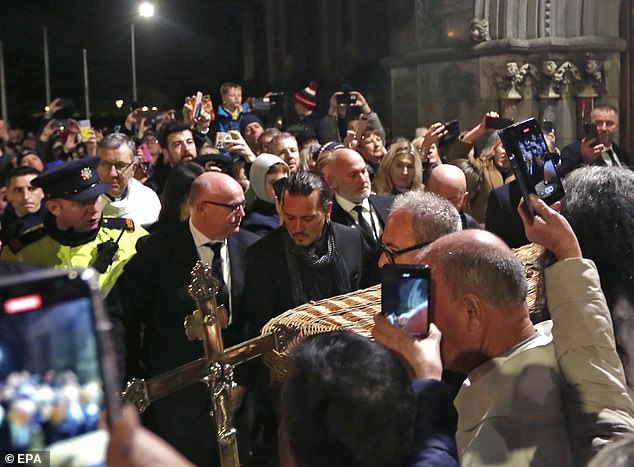 Celebrity Johnny Depp (center) among the pallbearers carrying the wicker coffin