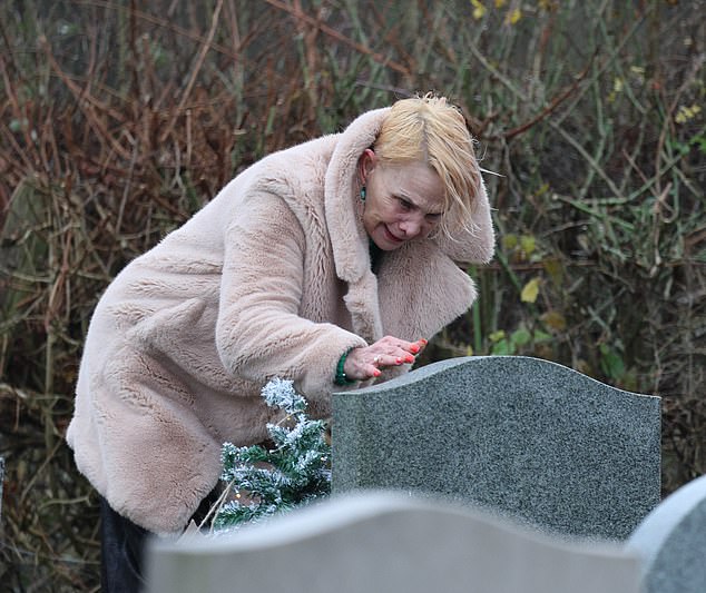 She was seen stooping to speak as she visited the grave