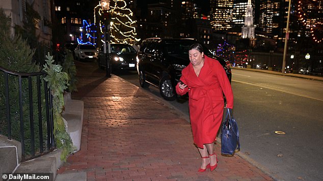 A woman in a smart red outfit is pictured arriving at Wednesday night's Electeds of Color party at a taxpayer-funded facility in Boston