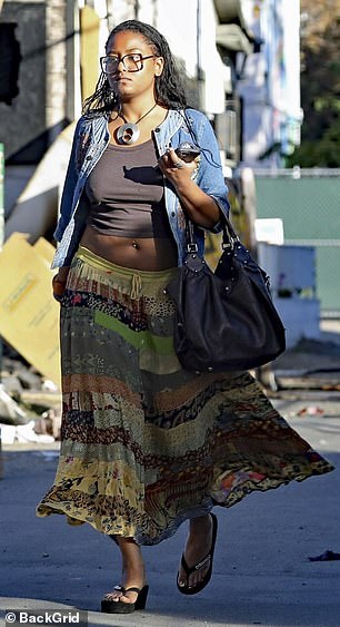 She paired the ensemble with a floral embellished denim jacket, platform slides, a dark handbag and brown framed glasses.