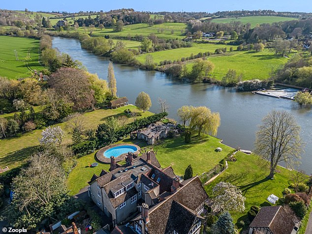 The property features a private boathouse and a kidney-shaped swimming pool in the garden