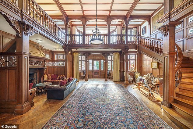 The hallway has a large fireplace that extends from the floor to the floor of the gallery