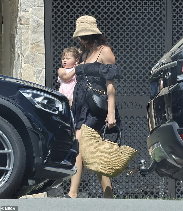 Dressed in all pink, Georgia's first child looked adorable in her long dress as her famous mom carried her to their car