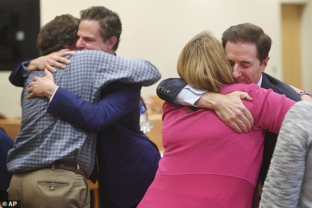 Families of the victims embrace their legal team on October 12, 2022