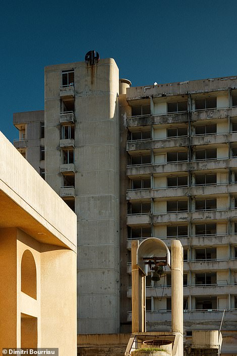 This creepy photo shows a clock tower standing in front of a spooky tower building