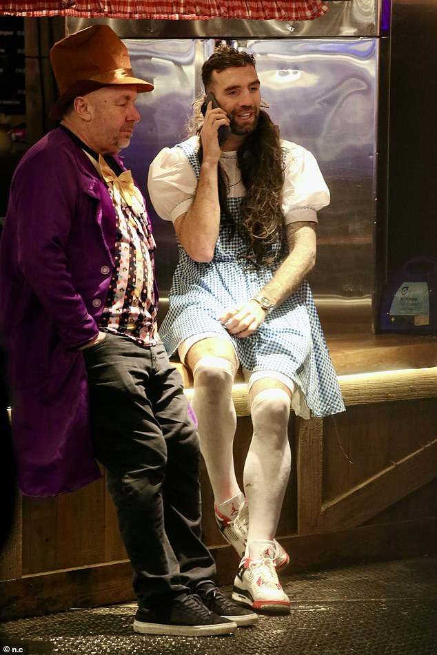 Shane dressed up as Dorothy from The Wizard Of Oz for a night out, complete with a blue gingham dress and a long curly wig