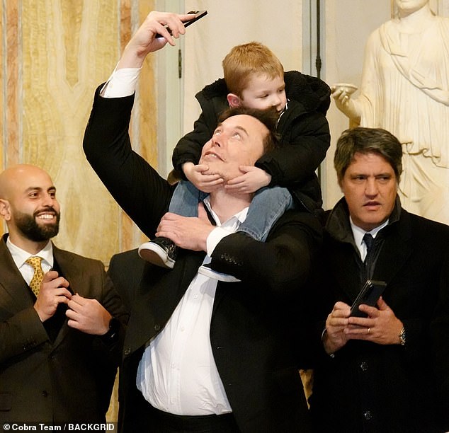 Musk stood tall with his son wrapped around his shoulders as he took a photo