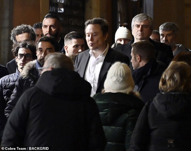 A large group of security guards are seen surrounding the billionaire as he plays tourist in Rome