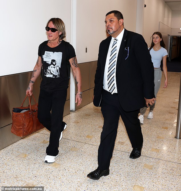 The tattooed showman completed his look with sunglasses, white sneakers and a silver bracelet, while carrying a brown leather duffel bag in one hand